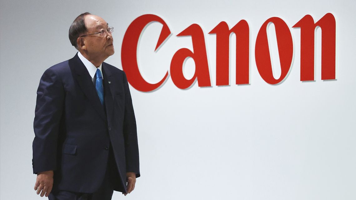 キヤノンのロゴと御手洗冨士夫会長兼社長CEO
